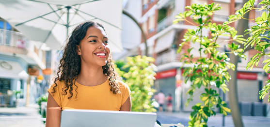 Young african american student girl using laptop sitting on the table at terrace.; Shutterstock ID 1928460668; purchase_order: -; job: -; client: -; other: -