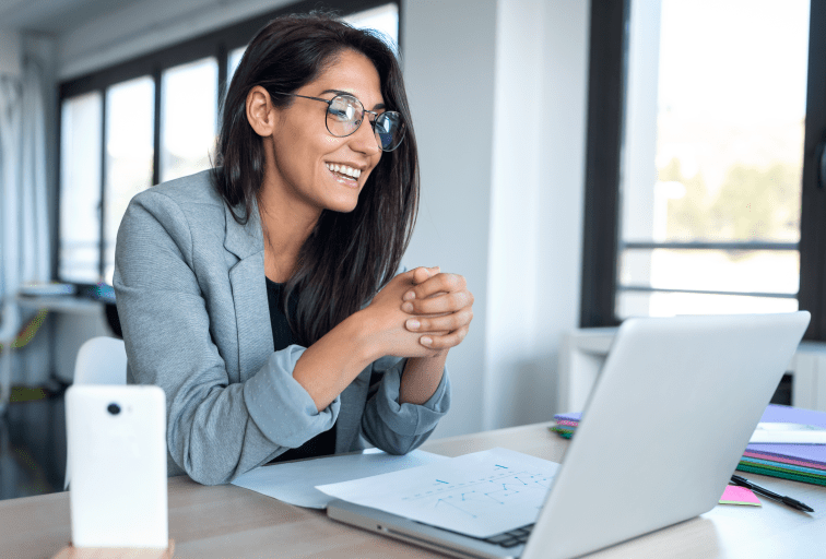 Shot of confident business woman looking and speaking through the webcam while making a video conference with laptop from the office.