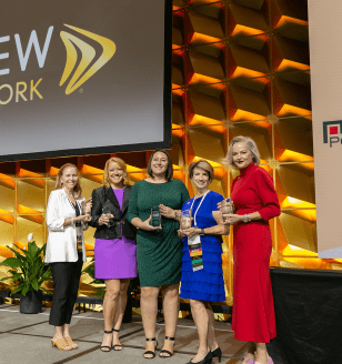 Women smiling holding awards