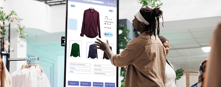 Customer using touch display shopping for fashion items in clothing store, interactive board. African american man choosing stylish clothes with different designs, modern kiosk service.