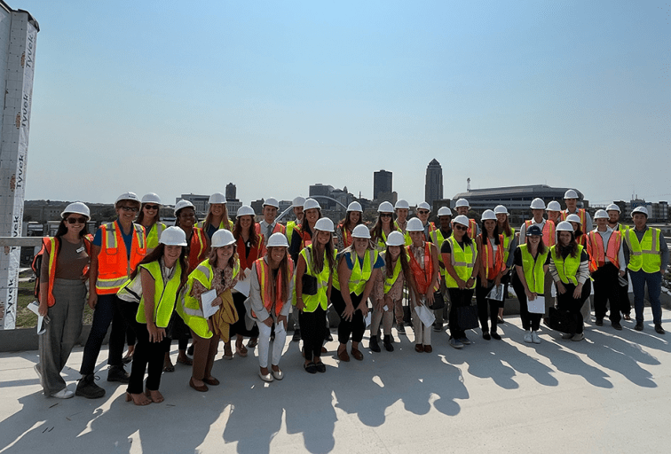 students in high visibility jackets and hard hats on a job site