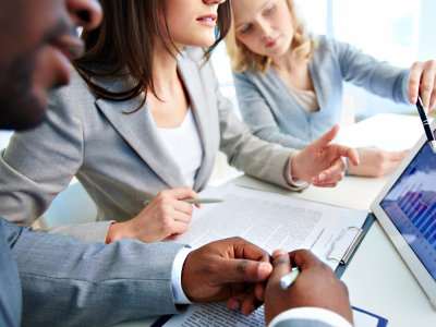 Close-up of young businesswomen discussing document in touchpad