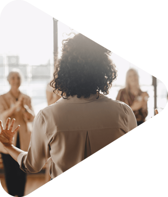 Businesswoman with arms outstretched talking to a small group