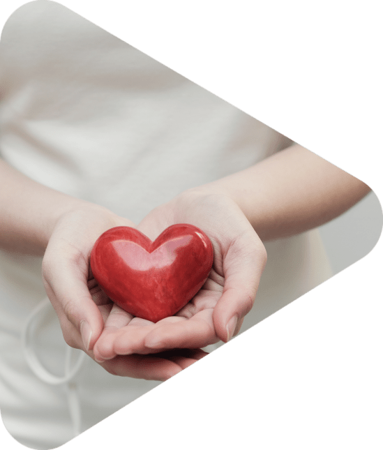 woman offering a red heart-shaped stone to camera